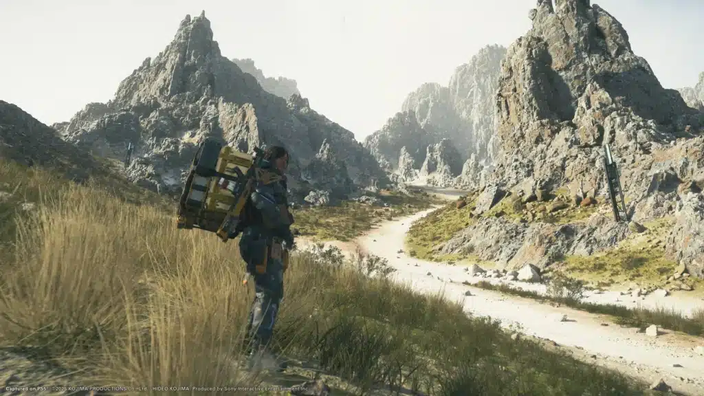 Sam traverse une vallée rocheuse dans Death Stranding 2
